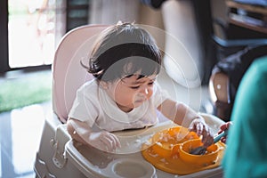 Portrait of cute baby eating dirty on the table