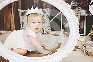 Portrait of a cute baby girl with paper crown