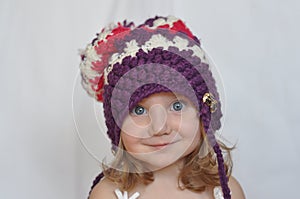 A portrait of a cute baby girl in a violet cap