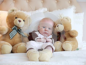Portrait of a cute baby lying on the white bed