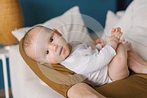 Portrait of a cute baby of six months lying on his father