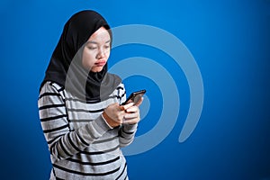 Portrait of cute beautiful Asian muslim teenage girl wearing hijab crying sad when receiving bad news on phone