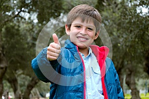 Portrait of a cute blond-haired boy, thumbs up and smile