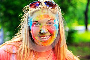 Portrait of cute blonde girl with colorful paint on her face.