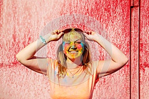 Portrait of cute blonde girl with colorful paint on her face.