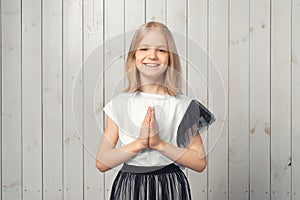 Portrait of cute blonde teen girl pleads for something, asks for favour, makes request gesture