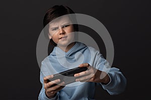 Portrait of Cute boy 10-12 years old with gamepad in hands playing video game. Childhood, facial expression concept
