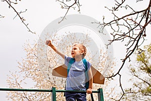 Portrait of cute boy on climbing frame holding hand up