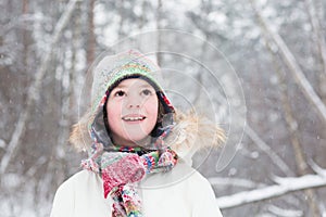 Portrait of cute boy in the woods under snow storm