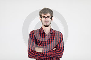 Portrait of a cute caucasian man wearing eyes glasses with a beard in casual business clothe standing fold arms and smiling with a