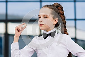 Portrait of cute caucasian teen girl holding coin. Saving money concept