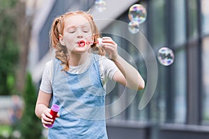 portrait of cute child blowing soap bubbles