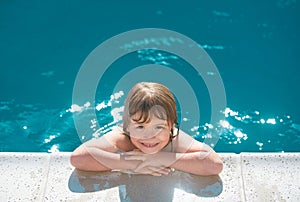 Portrait of a cute child boy. Caucasian kids face. Funny kid in swimming pool. Kids summer activities.