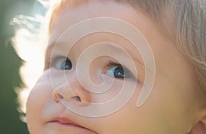 Portrait of a cute child boy. Close up caucasian Baby kids cropped macro face. Closeup head of funny kid outdoor.