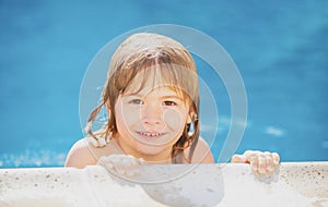 Portrait of a cute child boy in swimming pool. Close up caucasian kids face. Closeup head of funny kid. Kid relax in
