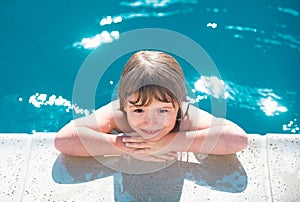 Portrait of a cute child boy in swimming pool. Close up caucasian kids face. Kids summer activities.