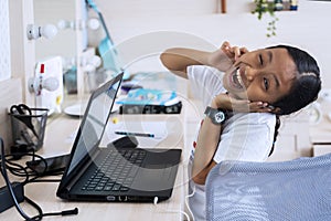 Cute child learning with earphone and laptop photo