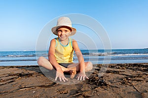 Portrait of a cute child sitting on a rocks near the sea