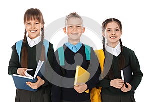 Portrait of cute children in school uniform with backpacks and books