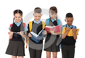 Portrait of cute children in school uniform with books on white