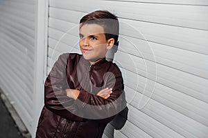 Portrait of cute fashionable boy in front of wooden wall