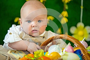 Portrait of a cute funny baby with an easter basket of eggs