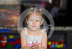 Portrait of cute and funny little girl wrinkling her nose photo