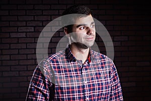 Portrait of cute funny young guy in a plaid shirt