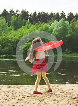Portrait of cute girl dance with red Scarf at the river
