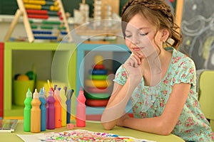 Portrait of cute girl drawing picture at home