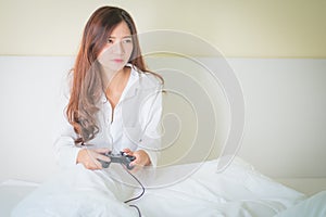 Portrait of a cute girl playing video games while she is lying o