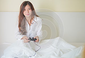 Portrait of a cute girl playing video games while she is lying o