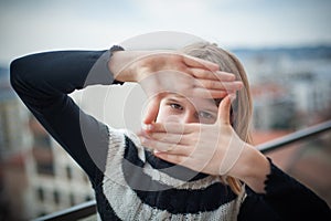 Portrait, cute girl shaping imaginary picture frame with her finger