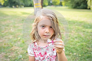 Portrait of cute girl is showing a hair clip in a public park