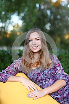 Portrait of cute girl sitting in chair and smiling in photograph