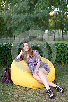 Portrait of cute girl sitting in chair and smiling in photograph