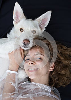 Portrait of a cute girl - a teenager of 17-18 years old next to her white dog