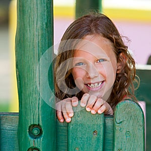 Portrait of cute girl at wooden fence.