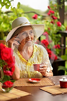 Portrait of cute happy aged woman drinking coffee