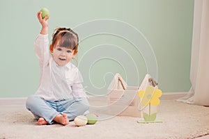 Portrait of cute happy baby girl playing with easter decorations