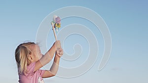 Portrait of cute happy girl having fun with pinwheel