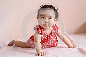 Portrait of cute happy little Asian baby girl wearing red dress looking out, baby expression concept