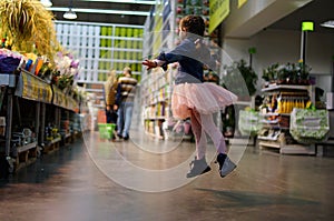 Portrait of cute little dancing girl in supermarket