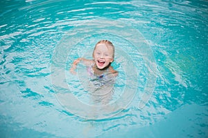 Portrait of cute happy little girl having fun in swimming pool,