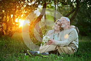 Portrait of cute happy senior couple sitting outdoors