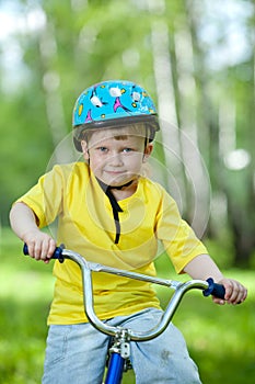 Portrait of a cute kid on bicycle outdoors