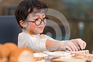 Portrait cute little Asian happiness boy interested in baking bakery with funny in home kitchen. People lifestyles and Family.