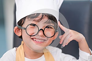 Portrait cute little Asian happiness boy interested in cooking with mother funny in home kitchen. People lifestyles and Family.