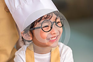 Portrait cute little Asian happy boy interested in cooking with mother funny in home kitchen. People lifestyles and Family.