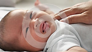 Portrait of cute little Asian newborn baby crying while lying on bed
